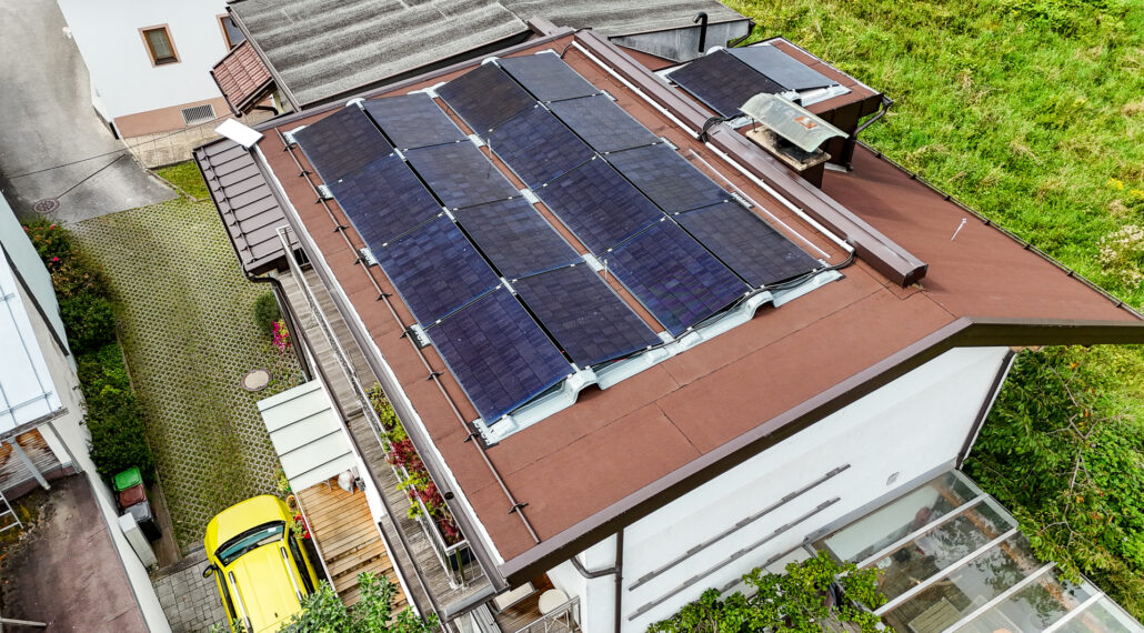 Mehrere Reihen an Photovoltaikmodulen auf einem flachen Dach